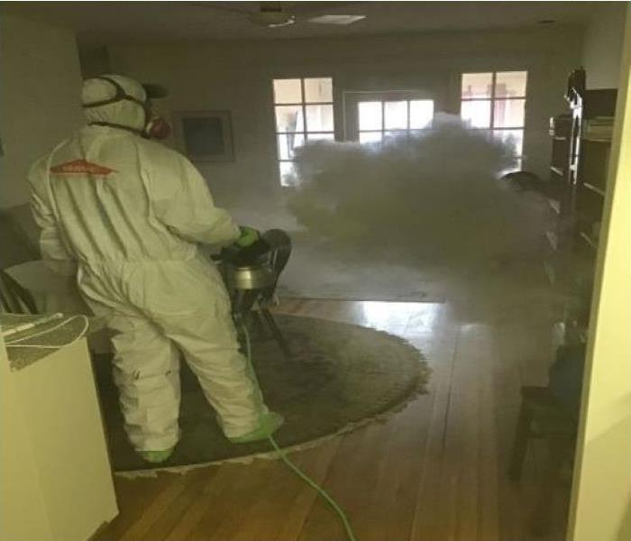 Technicians  in protective suit misting home