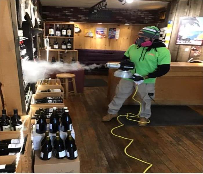 technician spraying wine bottles with disinfectant
