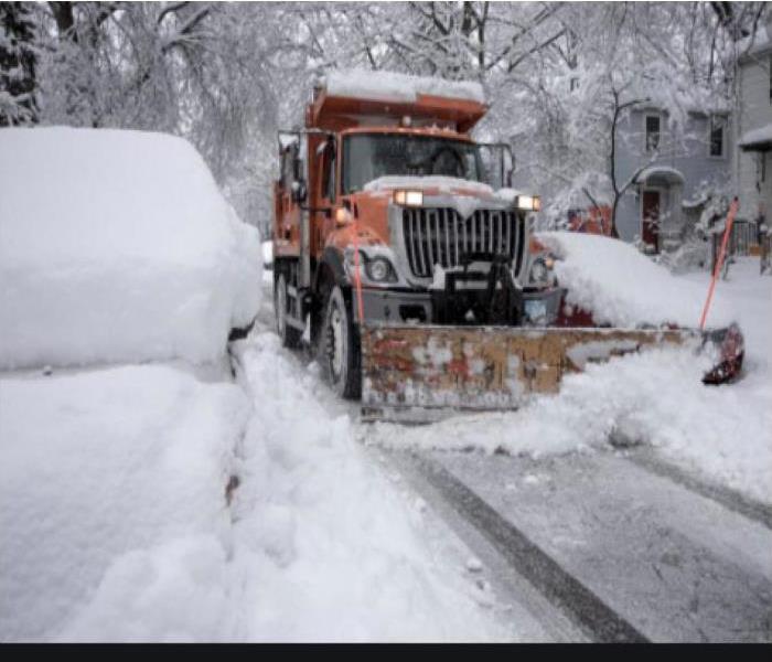 snow being plowed by truck 
